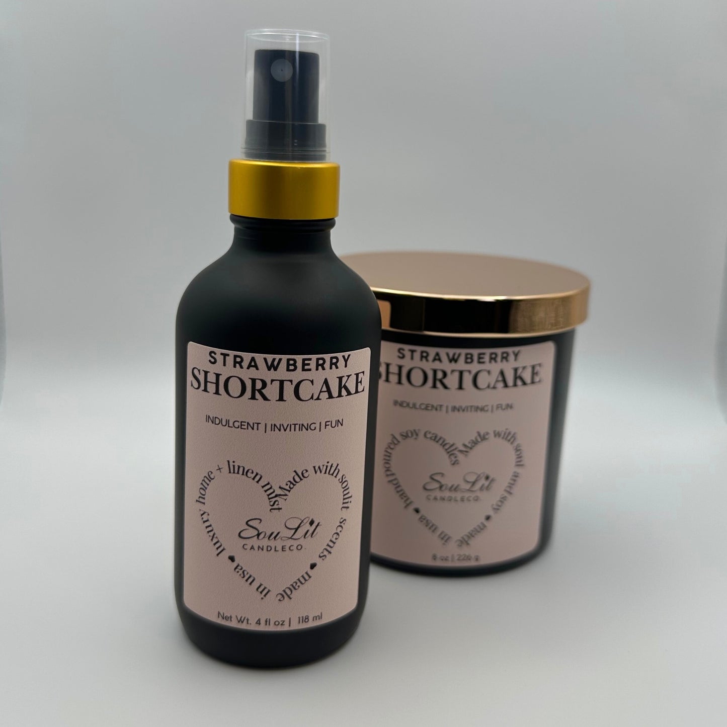 Air and linen mist in 4 oz matte black glass bottle with gold neck and a Soy candle in 8oz matte black glass jar with rose gold lid on white background.