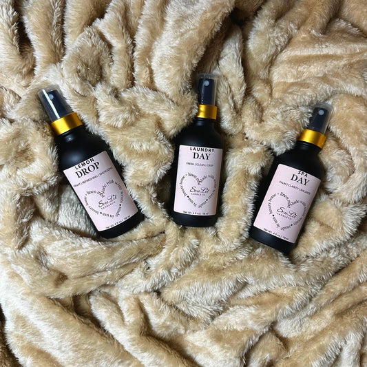 The Mist Trios Bundle includes three Air and linen mist in 4oz matte black glass bottles with a gold neck on a texture beige background.
