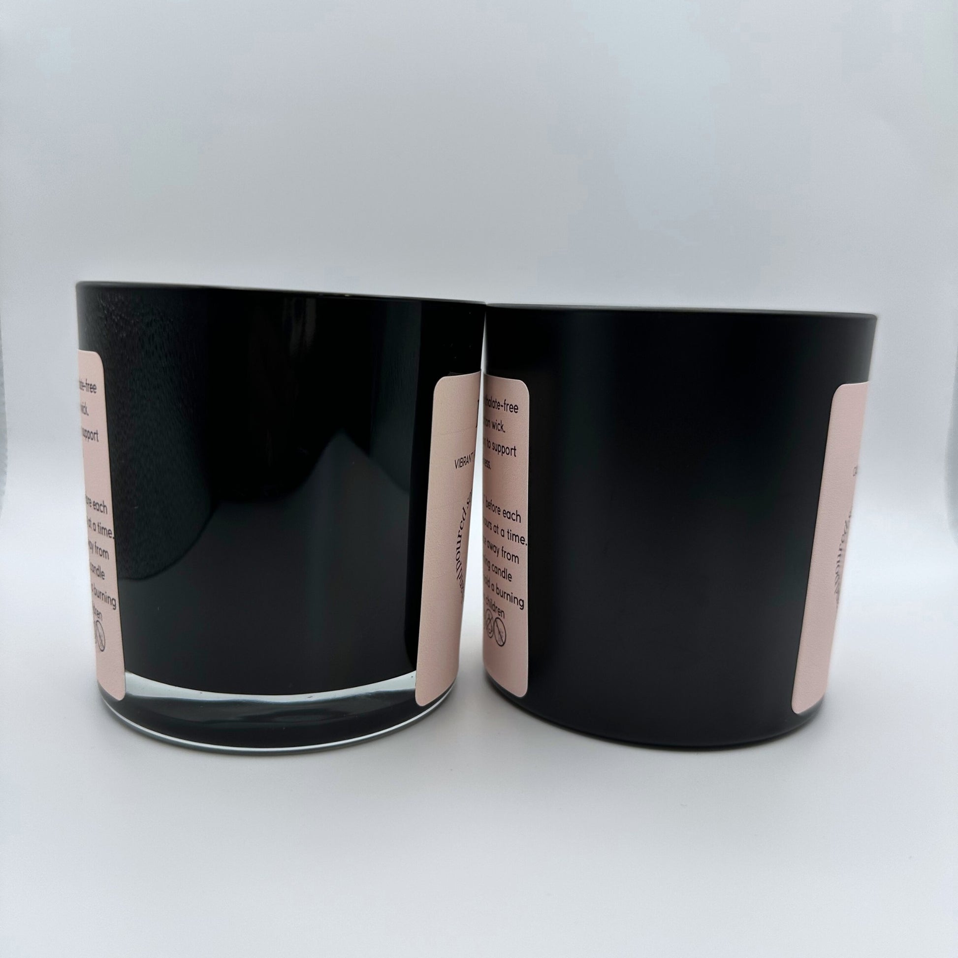 Two Soy candles, one in a 8oz matte black glass jar and one in a 8oz gloss black jar on white background. 