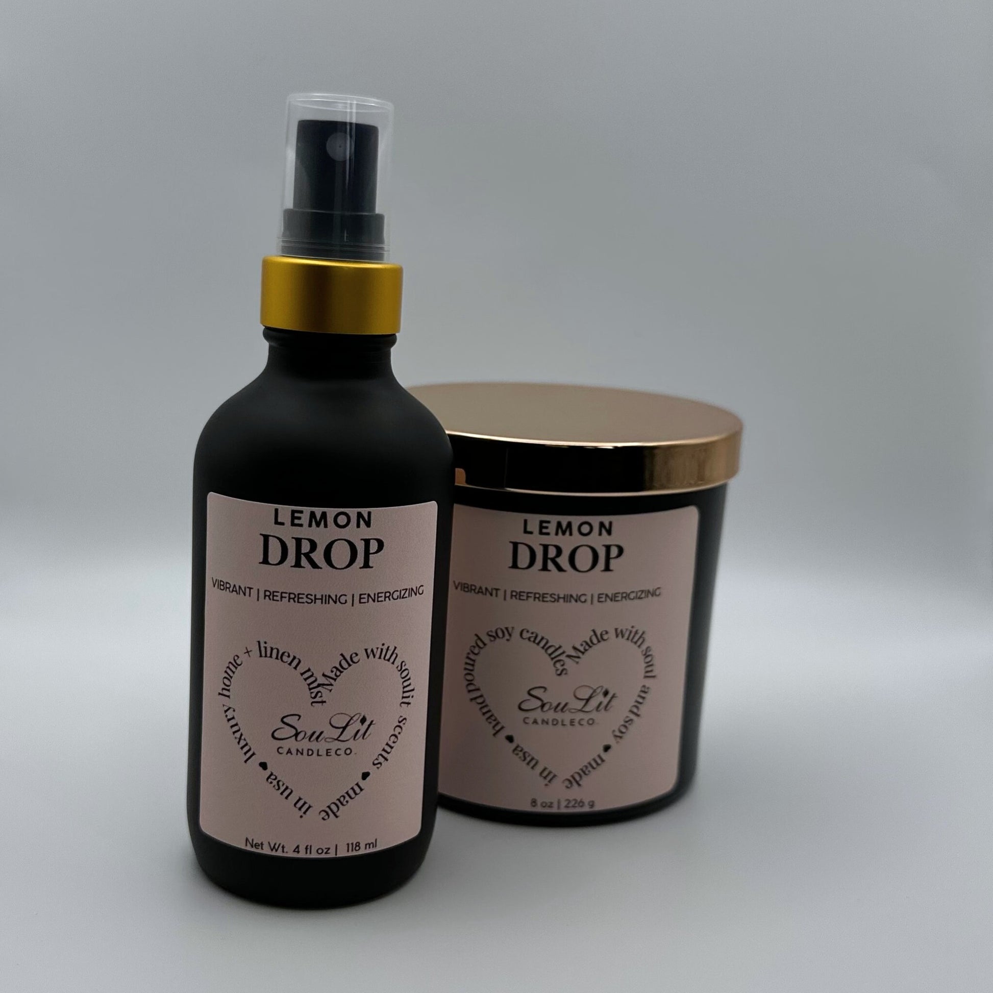 Air and linen mist in 4 oz matte black glass bottle with  gold neck and a Soy candle in 8oz matte black glass jar with rose gold lid on white background. 