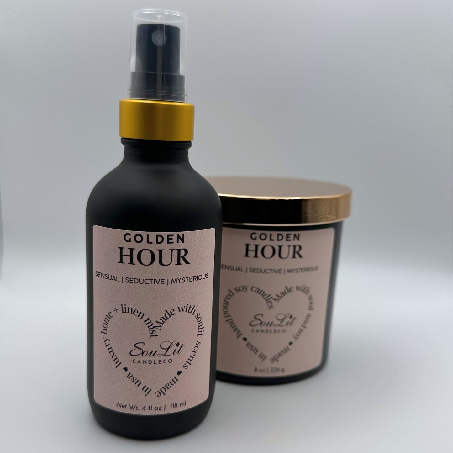 Air and linen freshener mist in 4 oz matte black glass bottle with  gold neck and a Soy candle in 8oz matte black glass jar with rose gold lid on white background. 