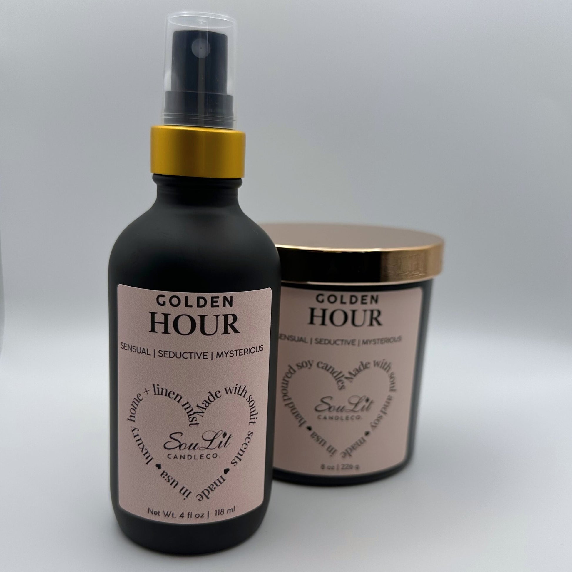 Air and linen freshener mist in 4 oz matte black glass bottle with  gold neck and a Soy candle in 8oz matte black glass jar with rose gold lid on white background. 