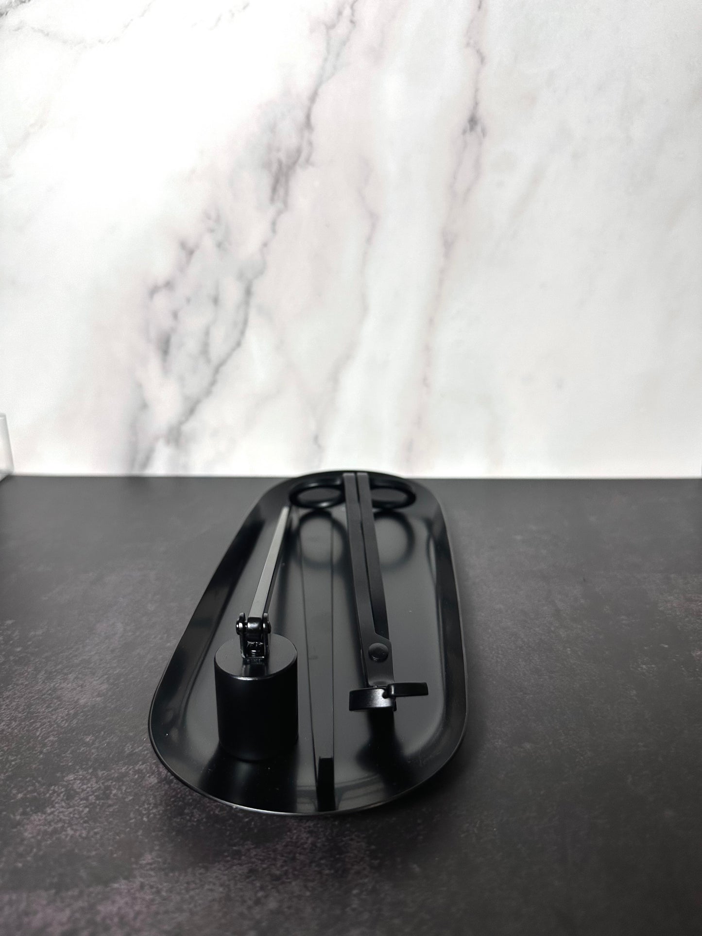 Semi-gloss black 4-piece candle care kit, with a wick trimmer, snuffer, and dipper on tray. 