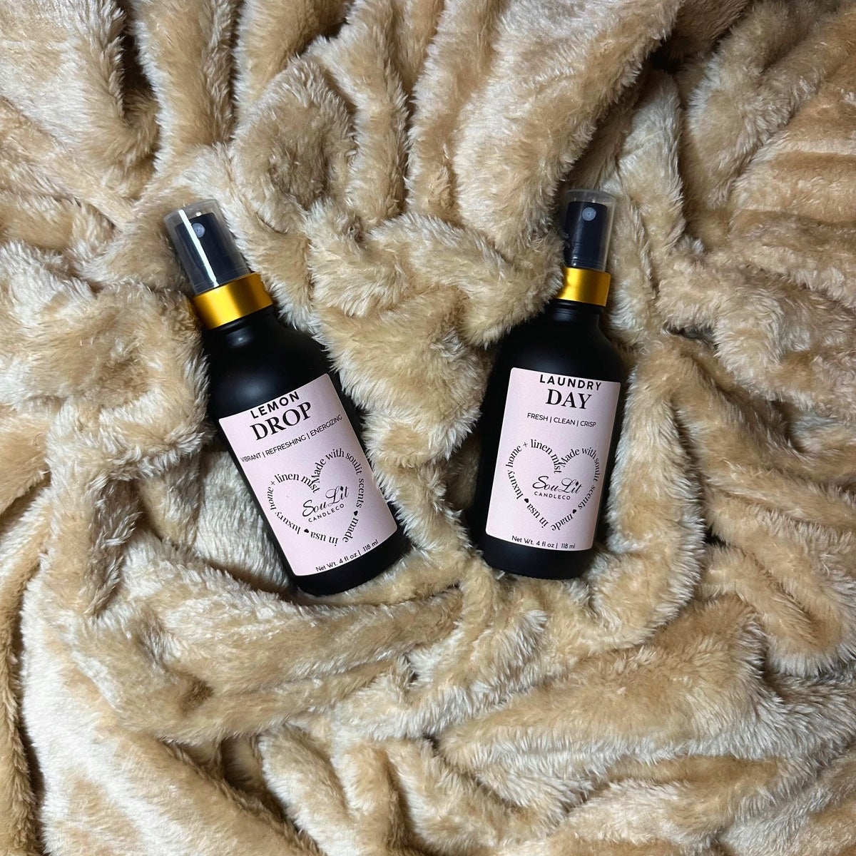 The Mist Duos Bundle includes two Air and linen mists in 4oz matte black glass bottles with a gold neck on a textured beige background. 