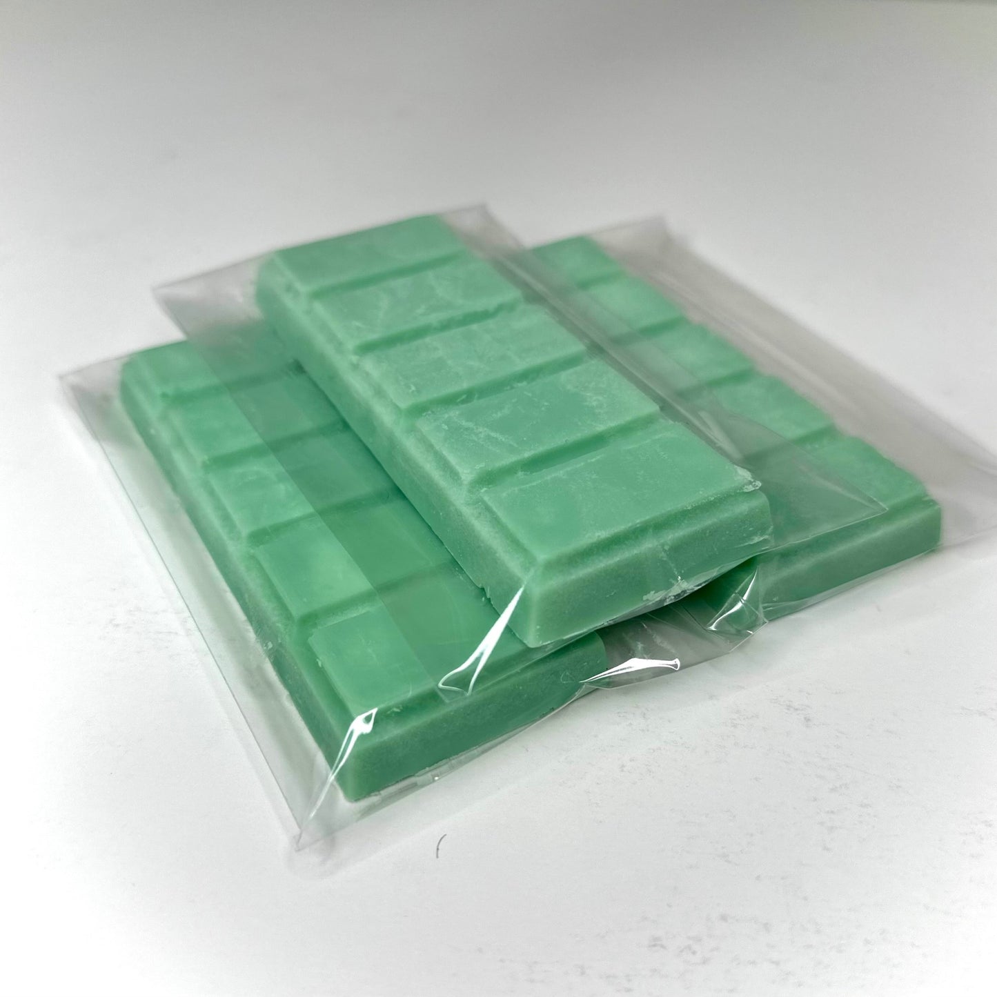 Three spa day (green color) wax melt bars on white background. 