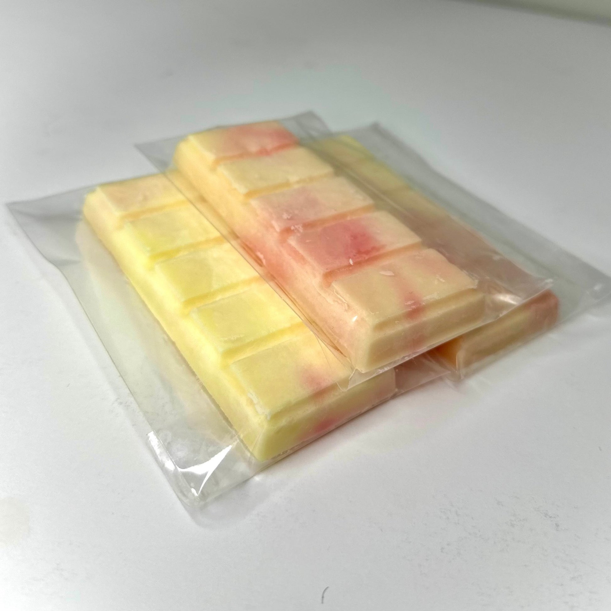 Three watermelon lemonade (yellow and pink abstract color) wax melt bars on white background. 